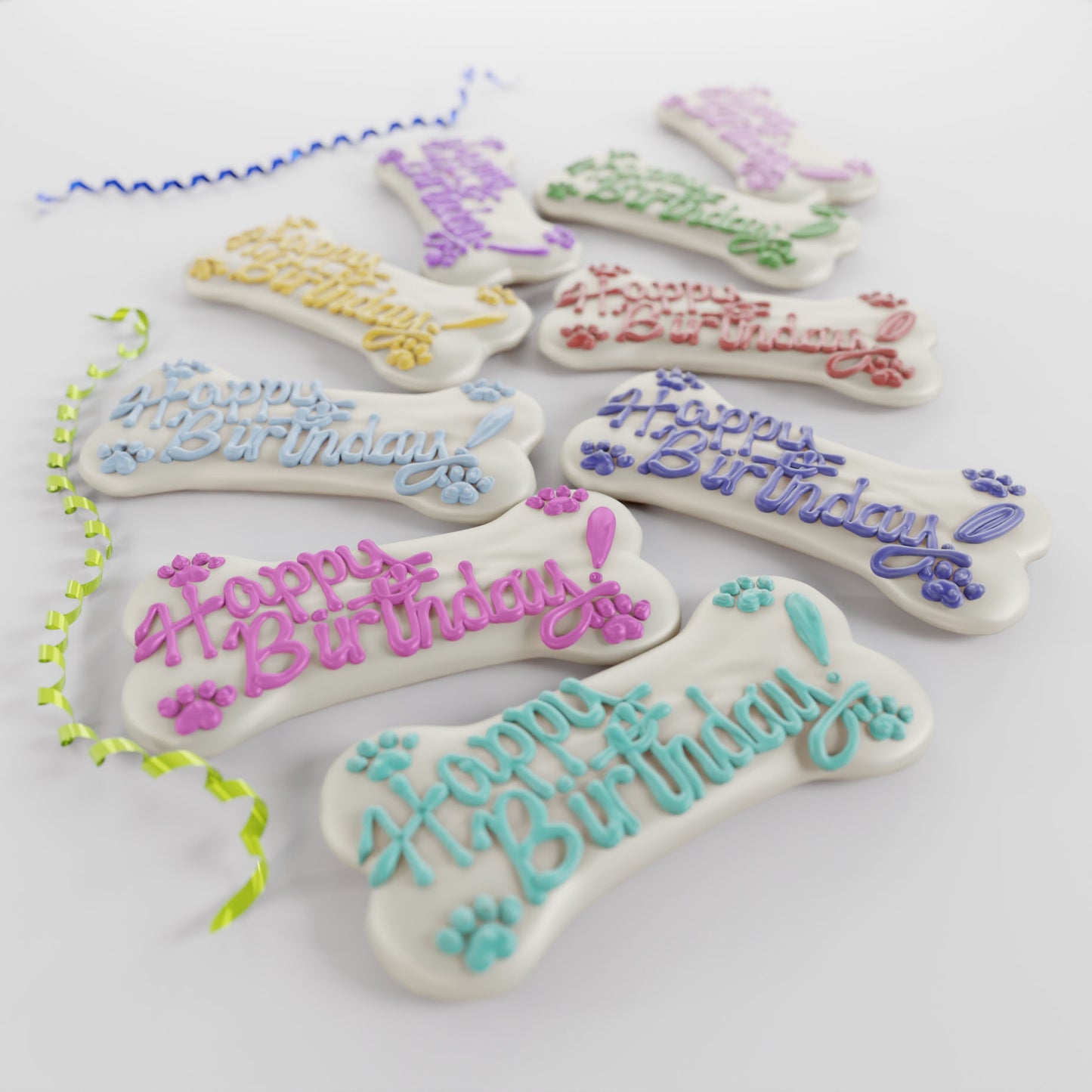 Assorted 5-inch Big Bone dog cookies with white yogurt icing and colorful celebration messages