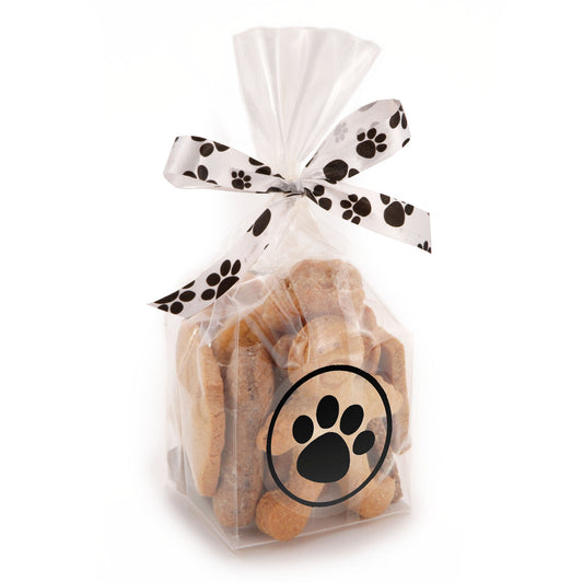 A clear cellophane bag filled with small tan dog treats, tied with a white ribbon printed with black paw prints, and featuring a black paw-print graphic on the front.