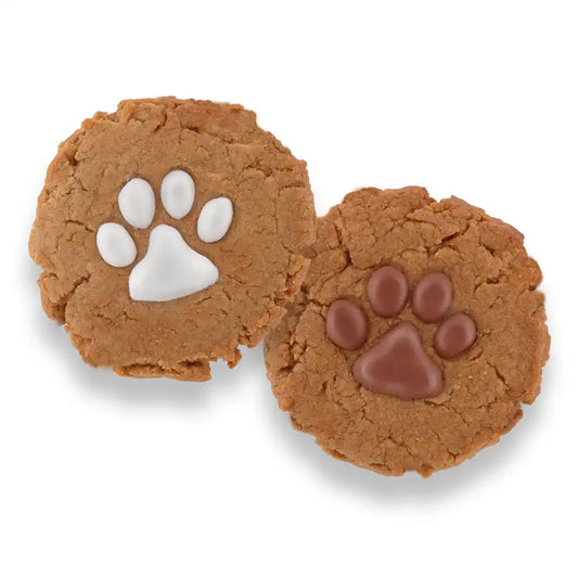 Two peanut butter dog cookies decorated with white yogurt and carob paw prints