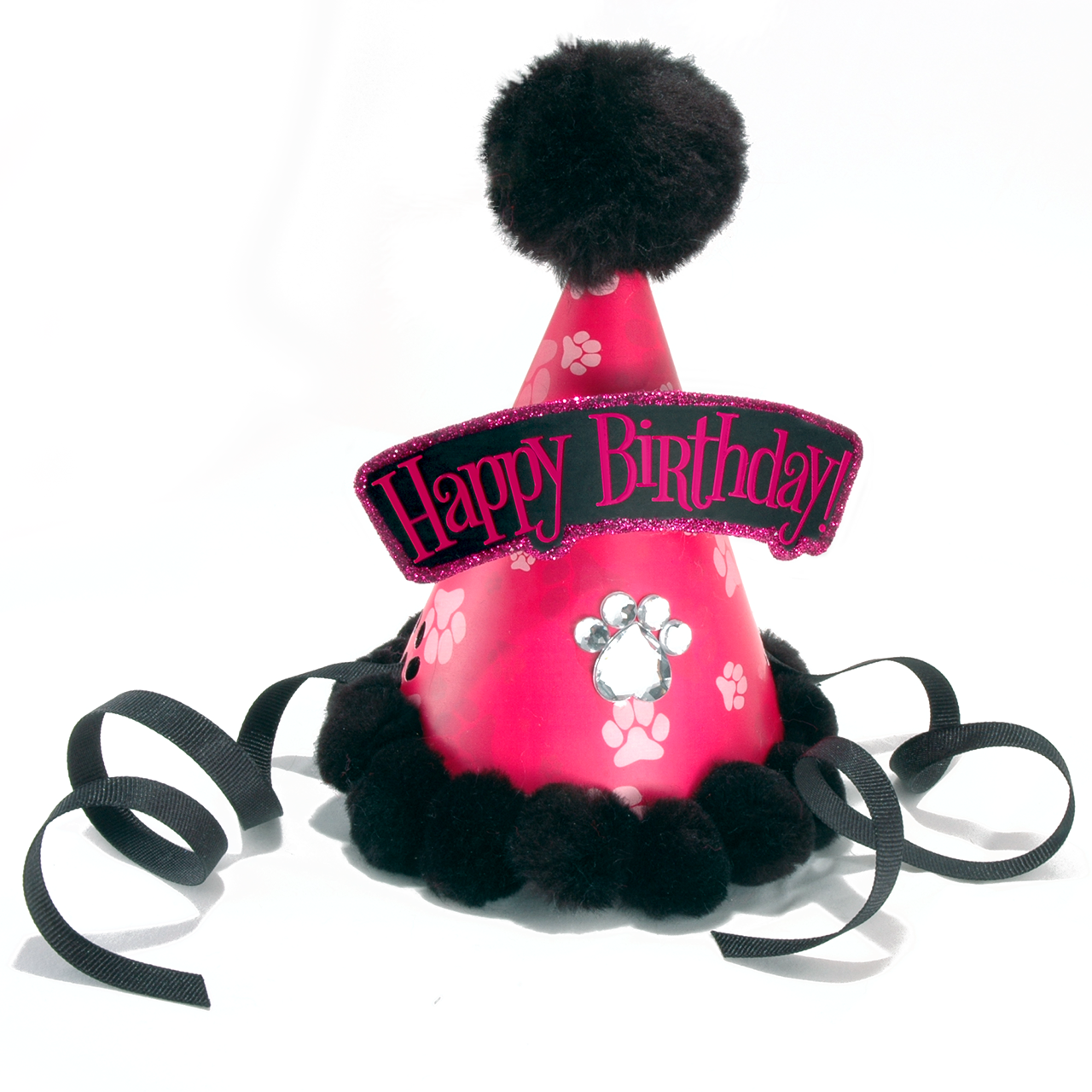 A pink pet party hat with black pom-poms, black ribbons, and a black glittery 'Happy Birthday' banner, decorated with white paw prints and a paw print patch on a white background.